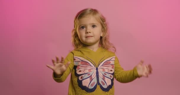 Портрет взволнованной маленькой девочки, изолированной на розовом фоне студии смеяться над смешной шуткой, радоваться счастливый маленький ребенок весело, детский юмор, развлекательная концепция Лицензионные Стоковые Видеоролики