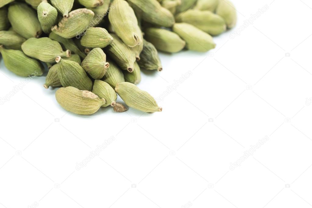 Lots of cardamom pods on white background