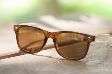 Ahşap masa üzerinde güneş gözlüğü.