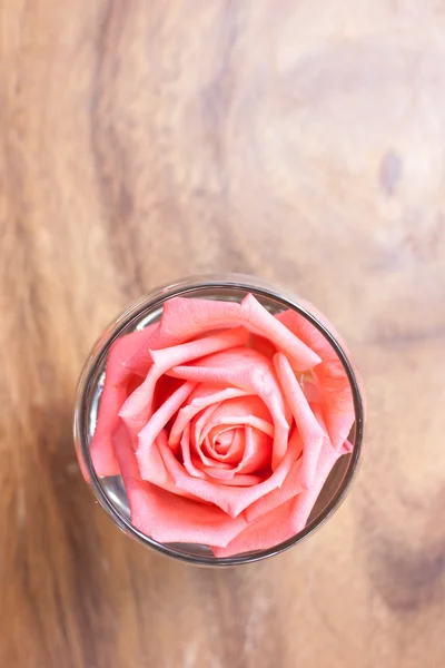 Rose in einem Glas schmücken auf dem Tisch. — Stockfoto