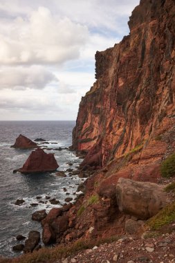 Günbatımında kayalık, kaya ve deniz manzaralı Doğu Madeira sahili manzarası. Ponta de Sao Lourenco. Atlantik okyanusu. Favori turistik mekan. Dikey fotoğraf yönelimi.