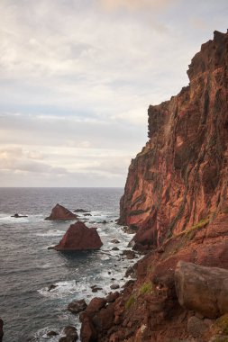 Günbatımında kayalık, kaya ve deniz manzaralı Doğu Madeira sahili manzarası. Ponta de Sao Lourenco. Atlantik okyanusu. Favori turistik mekan. Dikey fotoğraf yönelimi.