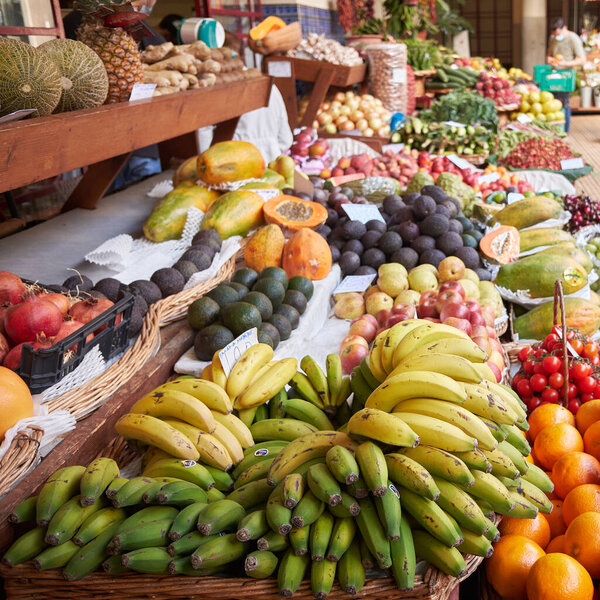 Stand with tropical fruit on the farmers market - bananas, avocados, papayas and oranges. Funchal, Madeira, Portugal.