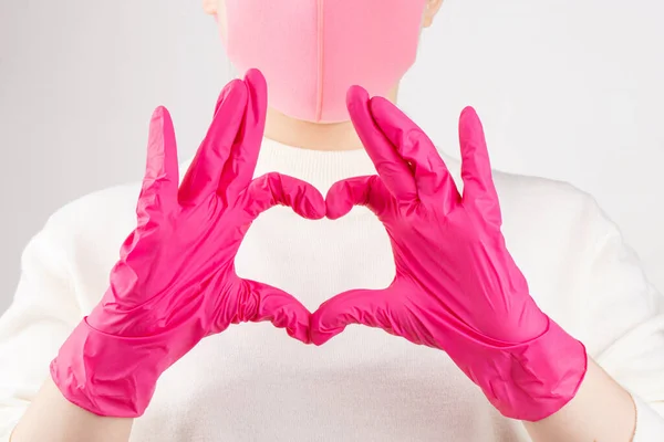 girl in pink gloves and mask on a white background