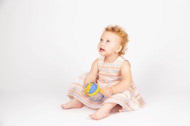 Açık arkaplanda kıvırcık saçlı küçük kız.