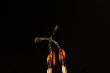 Tahta ışıklı kibrit, siyah arka planda duruyor.