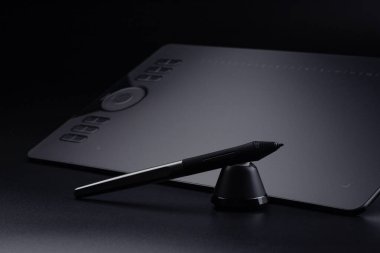 Bir stil ile grafik tablet ve siyah bir arkaplan üzerinde durmak