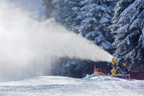snow cannon works in the mountains on the ski track