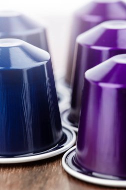 Kahve makinesi için kapsüller, doğal renklerden oluşan ahşap bir masanın üzerine serilmişti.