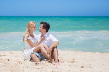 Çift kucaklayan ve güneşli bir günde sahilde poz