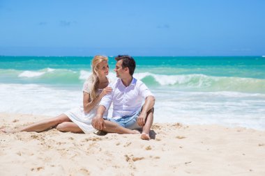 Çift kucaklayan ve güneşli bir günde sahilde poz