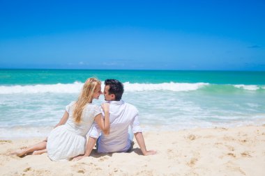 Çift kucaklayan ve güneşli bir günde sahilde poz