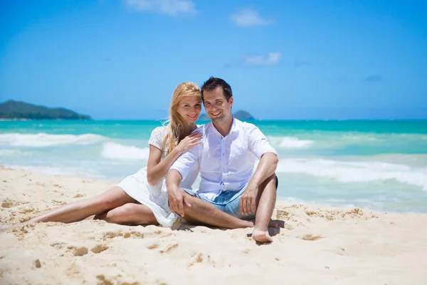 Pareja alegre abrazando y posando en la playa en un día soleado — Foto de Stock