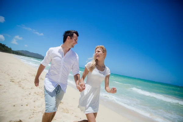 Casal correndo em uma praia de areia — Fotografia de Stock