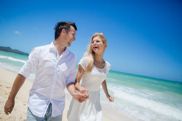 Casal correndo em uma praia de areia — Fotografia de Stock