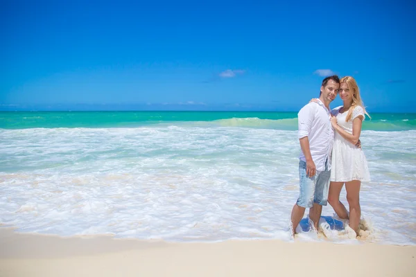 Fröhliches Paar, das sich an einem sonnigen Tag am Strand umarmt und posiert — Stockfoto