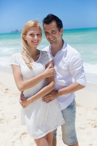 Cheerful couple embracing and posing on the beach on a sunny day Stock Image
