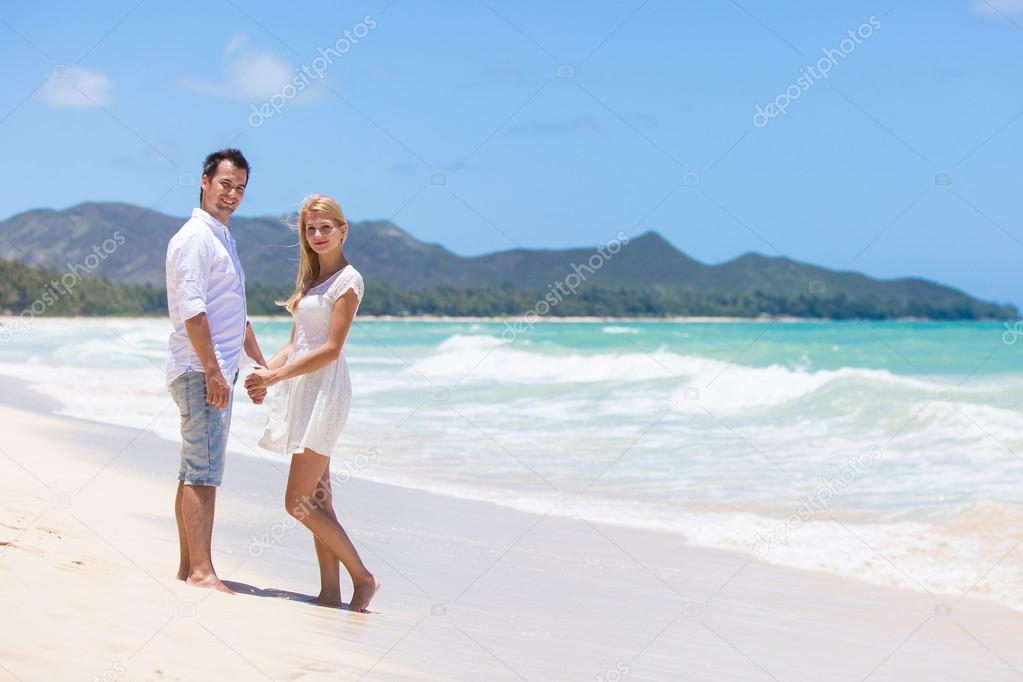 Happy couple walking on beach.