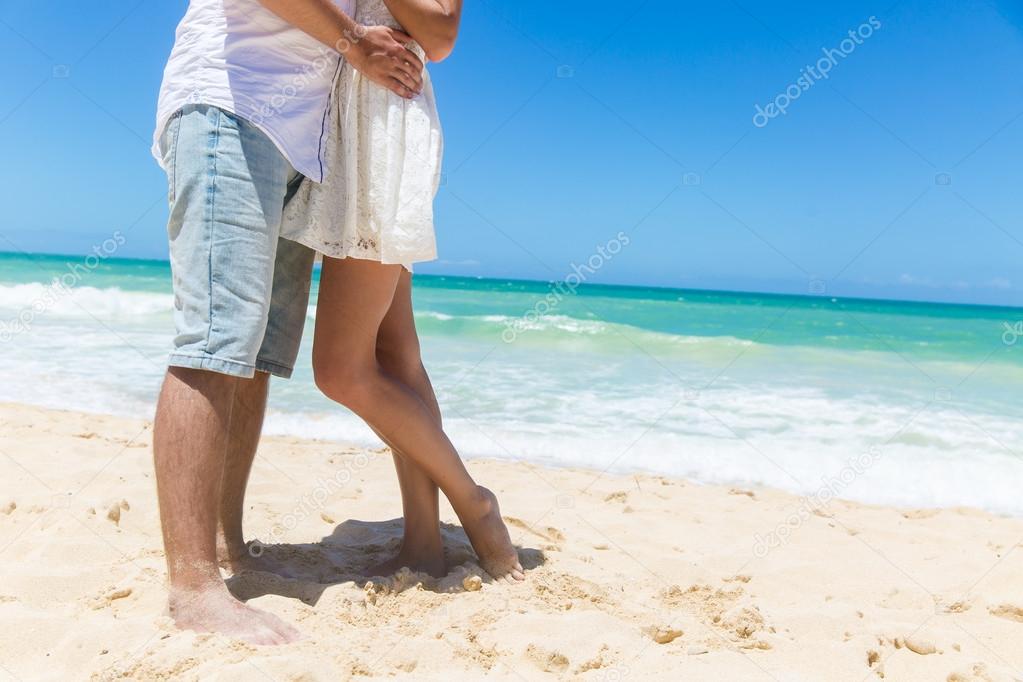 Romantic couple holding hands on the beach.