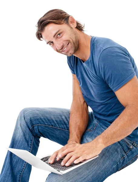 Przystojny młody mężczyzna pracujący na swoim laptopie — Zdjęcie stockowe