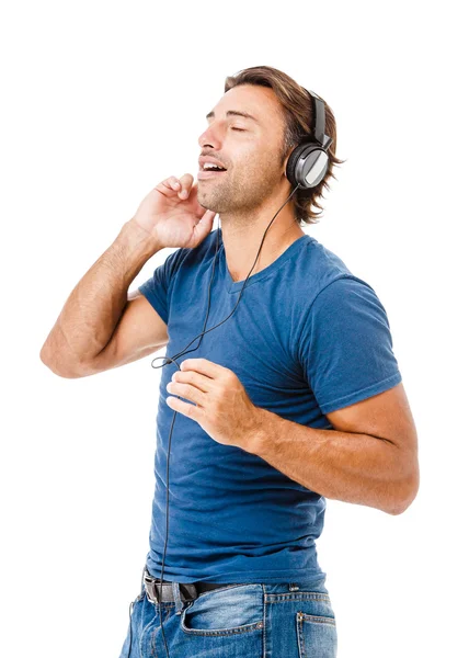 Joven escuchando música aislada sobre fondo blanco — Foto de Stock