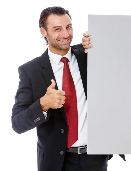 Joven hombre de negocios sonriente sosteniendo un cartel — Foto de Stock