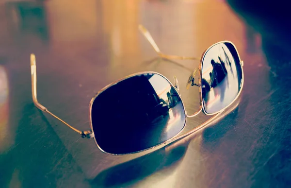 sun glasses on brown wood table