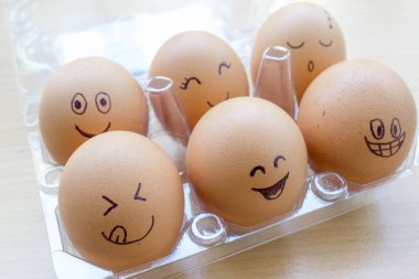 Kutuda yüzü boyalı komik yumurtalar.
