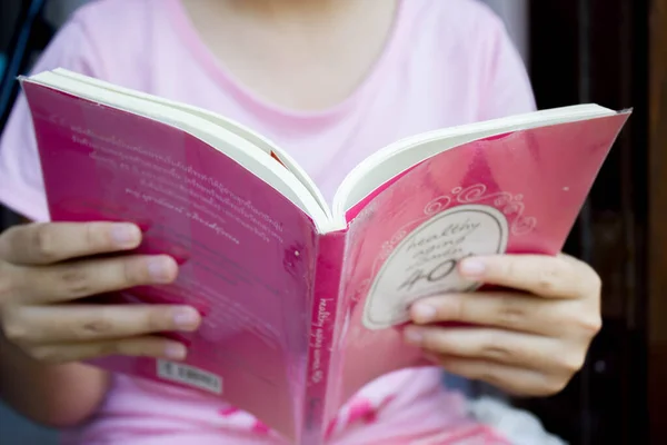 Close-up of girl hands reading  book