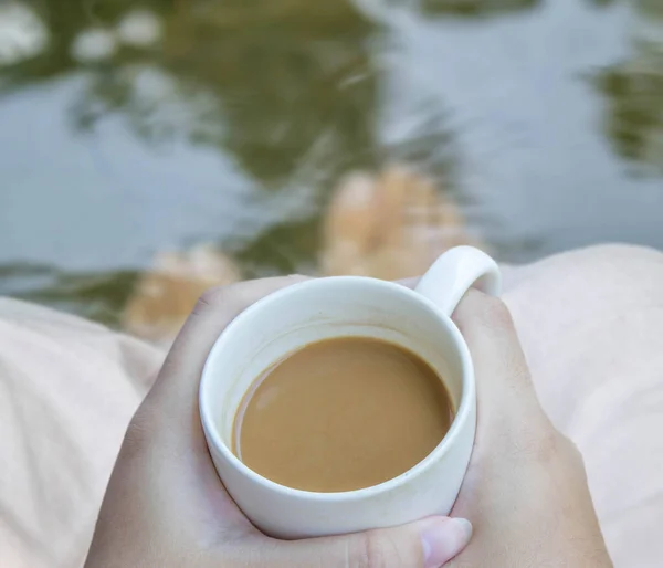 Nogi Relaksujące Się Wodzie Gorącą Kawą Dłoni — Zdjęcie stockowe