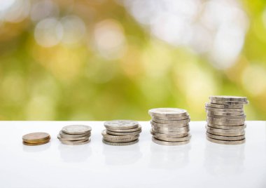 Grafik olarak düzenlenmiş bozuk paralar: doğanın bulanık arka planında kaydetmenin konsept fotoğrafı