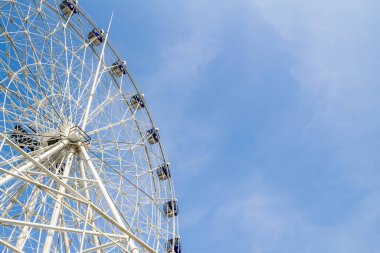 Mavi gökyüzünde dönme dolap ve beyaz bulut