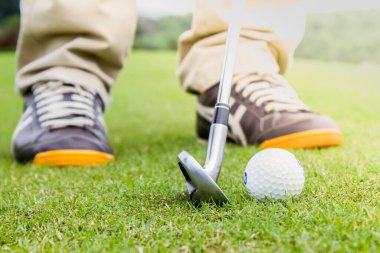 Golf oyuncusu güneş ışığıyla birlikte camda top oynuyor.