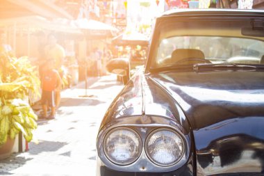 Eski model klasik arabanın lambasıyla yol kenarında güneş ışığı...