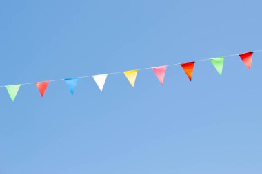 Mavi gökyüzü arka planında renkli bayrak bayrağı