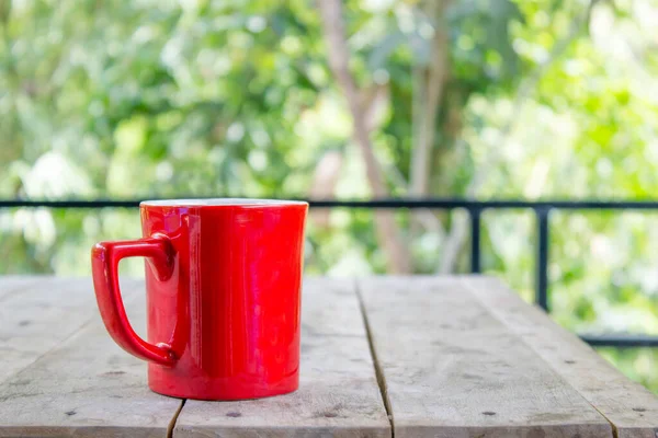 Cangkir Kopi Merah Meja Kayu Dengan Latar Belakang Alam Bokeh — Stok Foto