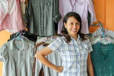 Elbise dükkanında gülümseyen Asyalı kadın.