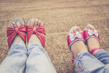 Anneler Günü için anne ve kız bacakları yan yana oturur.