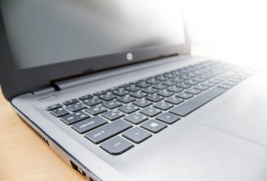 Ev Bulcony 'deki ahşap masada dizüstü bilgisayar.