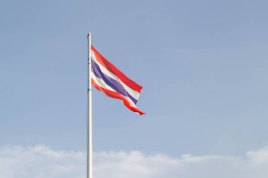 Mavi gökyüzünde Tayland bayrağı sallıyor ve beyaz bulut