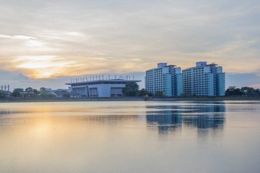 Gün batımında gökyüzü olan nehir ve bina