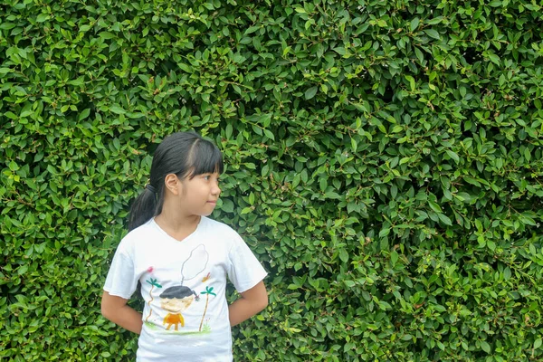 Ασιατικό Κορίτσι Παιδί Στέκεται Στο Φόντο Του Πράσινου Φυσικού Δέντρου — Φωτογραφία Αρχείου