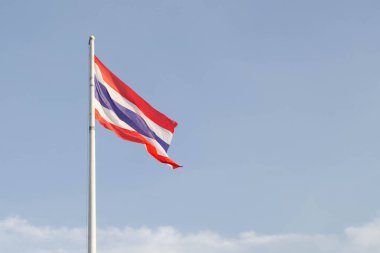 Mavi gökyüzünde Tayland bayrağı sallıyor ve beyaz bulut