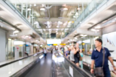 Havaalanındaki yürüyen merdivende turistlerin bulanık hareketleri