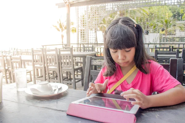 在餐馆用平板电脑吃饭的亚洲女孩 — 图库照片