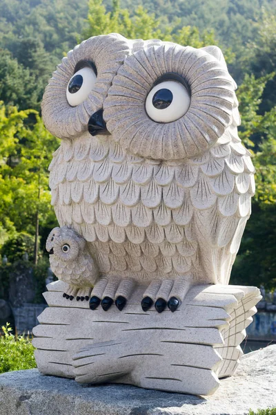 cute mom and kid owl statue in the natural green park