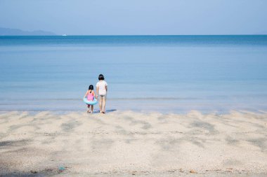İki Asain kızı sahile gidiyor.