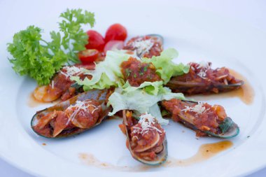 Kızarmış midye ve beyaz tabakta kırmızı sos.