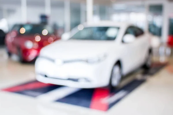 blurred car showroom with white and red car : for background use