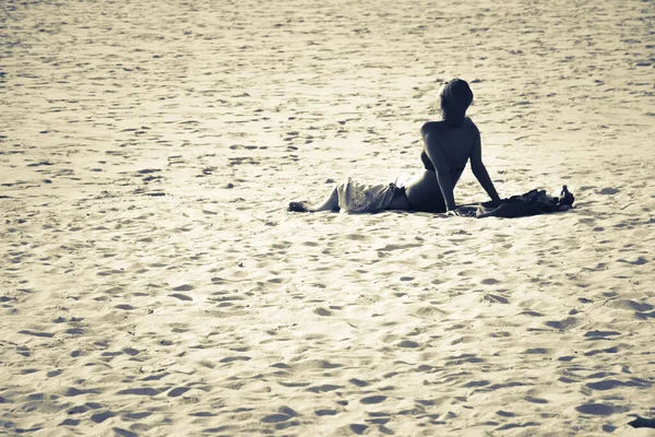 暑い太陽の光でビーチで日光浴をしている女性 — ストック写真
